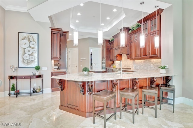 kitchen featuring backsplash, kitchen peninsula, crown molding, hanging light fixtures, and light stone counters