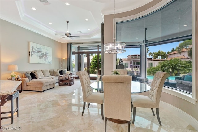 dining area with crown molding, french doors, ceiling fan with notable chandelier, and a tray ceiling