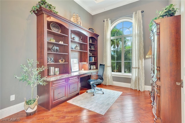 office featuring light wood-type flooring, ornamental molding, and plenty of natural light