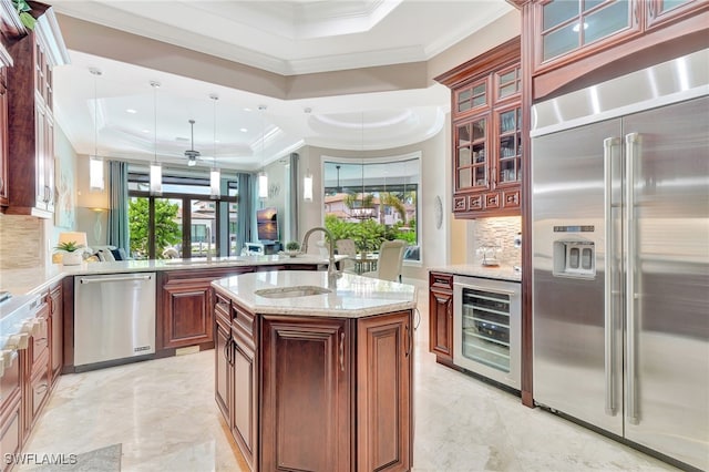 kitchen with beverage cooler, appliances with stainless steel finishes, sink, kitchen peninsula, and a tray ceiling