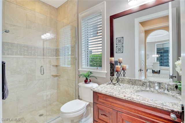 bathroom featuring toilet, walk in shower, and vanity