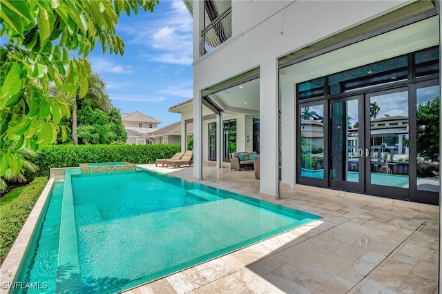 view of swimming pool with an in ground hot tub, a patio area, and french doors