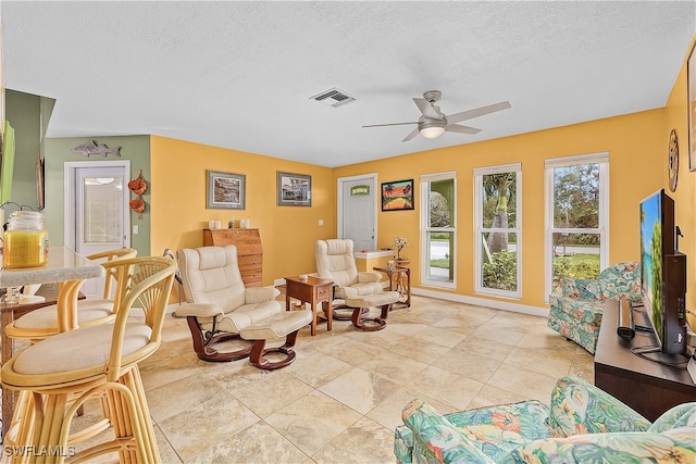 sitting room with a textured ceiling and ceiling fan