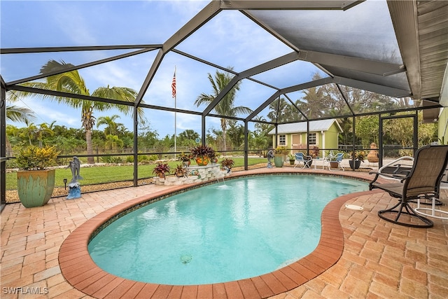 view of pool with pool water feature, a patio, and glass enclosure