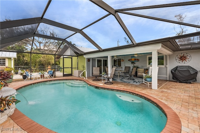 view of pool with a grill, a patio, and glass enclosure