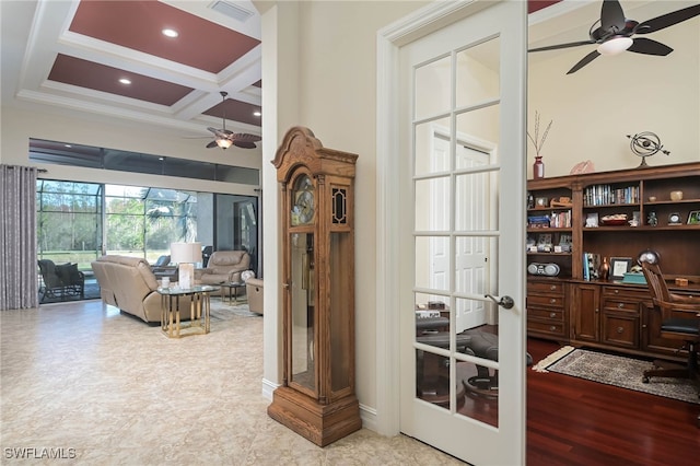 interior space with coffered ceiling, beamed ceiling, light hardwood / wood-style flooring, ornamental molding, and a towering ceiling