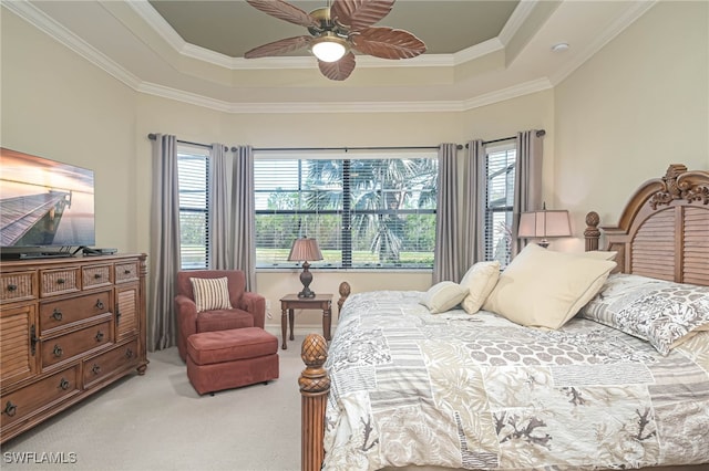 carpeted bedroom with ornamental molding, a raised ceiling, and ceiling fan