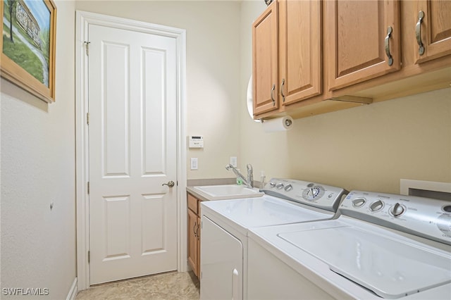 washroom featuring light tile patterned floors, cabinets, sink, and washer and clothes dryer