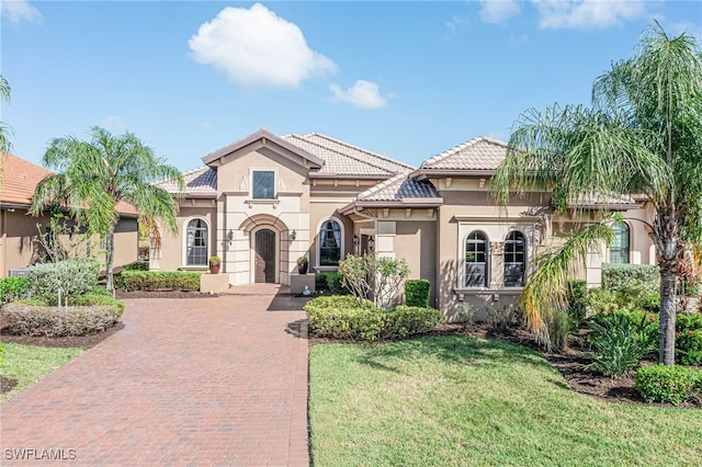 mediterranean / spanish home with a front yard