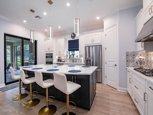 kitchen featuring decorative backsplash, appliances with stainless steel finishes, pendant lighting, and a kitchen island