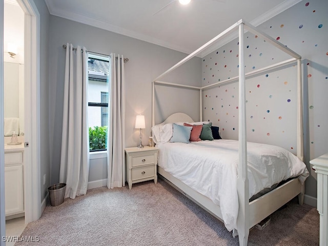 carpeted bedroom with ornamental molding, ensuite bath, and ceiling fan