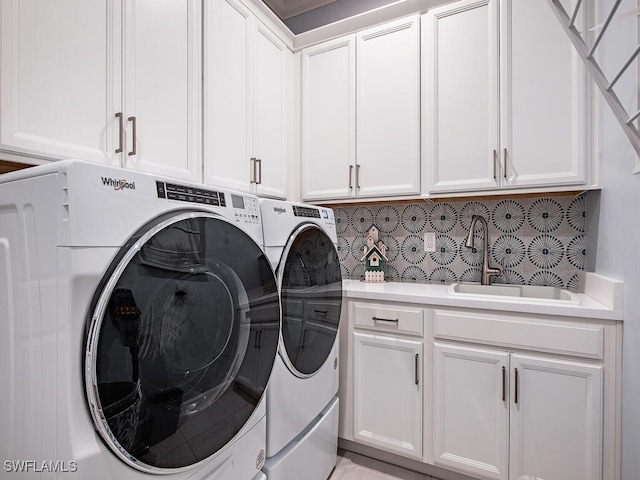 laundry area featuring cabinets, independent washer and dryer, and sink