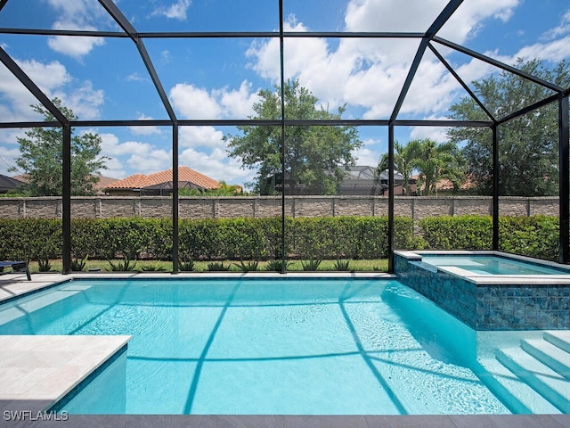 view of swimming pool with an in ground hot tub and glass enclosure