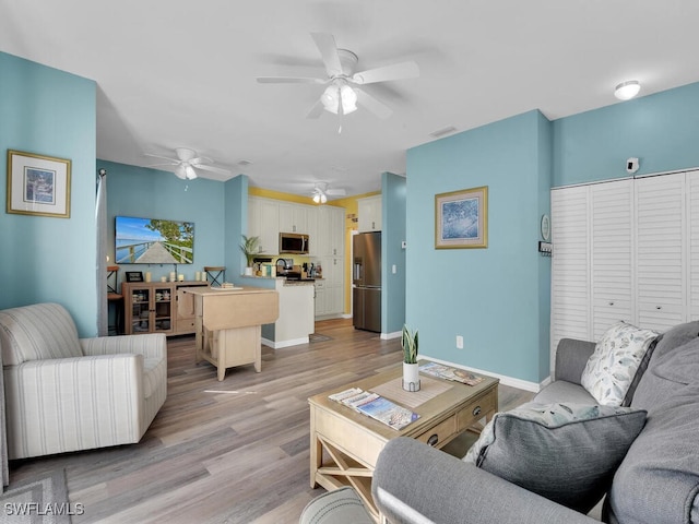 living room featuring light wood-type flooring and ceiling fan