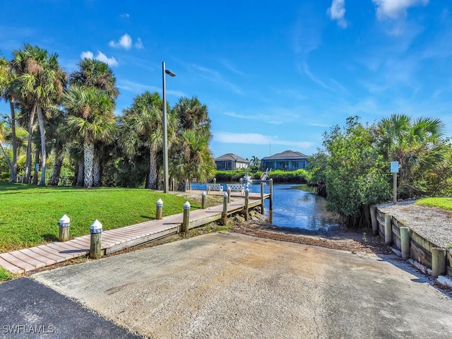 dock area with a lawn and a water view