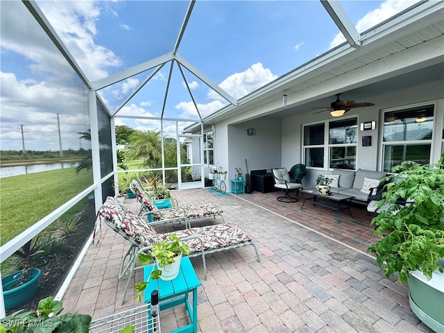 unfurnished sunroom with a water view and ceiling fan