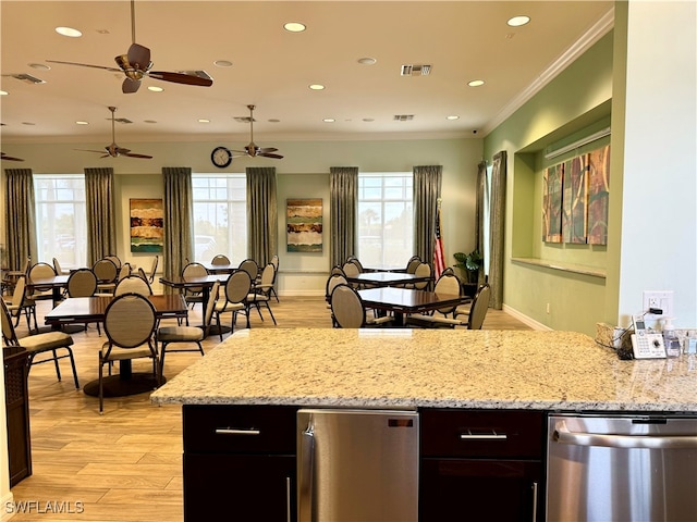 kitchen with ceiling fan, light stone countertops, stainless steel dishwasher, ornamental molding, and light hardwood / wood-style floors