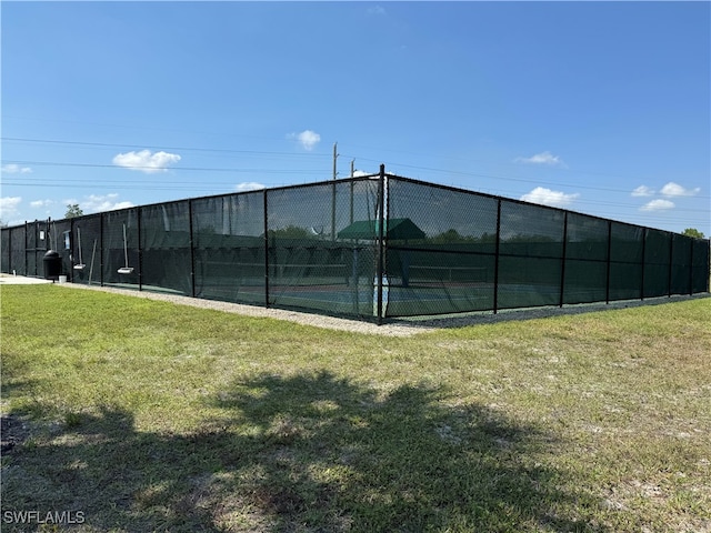 view of tennis court with a lawn