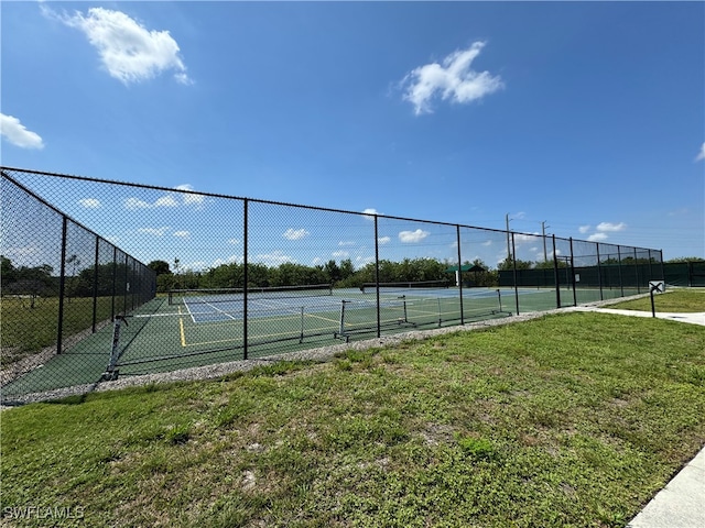 view of tennis court featuring a yard