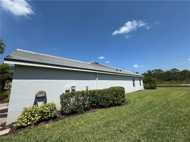 view of side of home with a yard