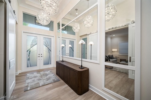 interior space featuring french doors, a high ceiling, beamed ceiling, a notable chandelier, and light wood-type flooring