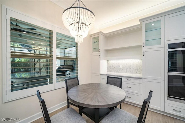 dining space with a notable chandelier and light wood-style flooring