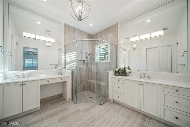 bathroom featuring an inviting chandelier, a sink, and a shower stall