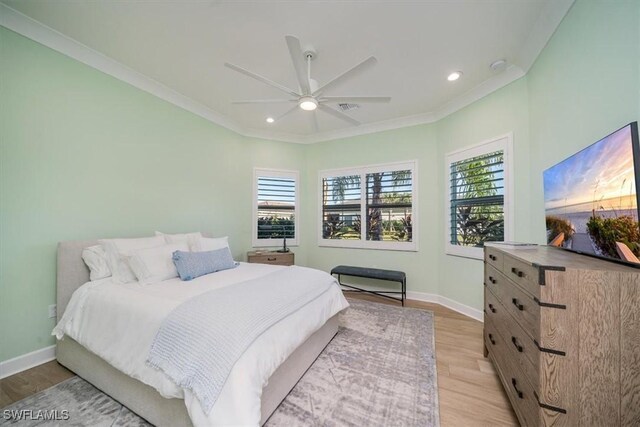 bedroom with crown molding, multiple windows, light wood-style flooring, and baseboards