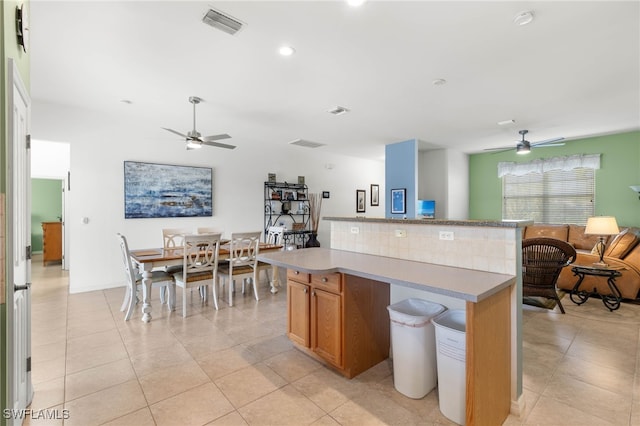 kitchen with ceiling fan, a kitchen island, and light tile patterned floors