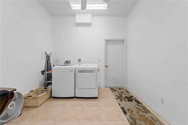 laundry room with washing machine and clothes dryer and light tile patterned flooring