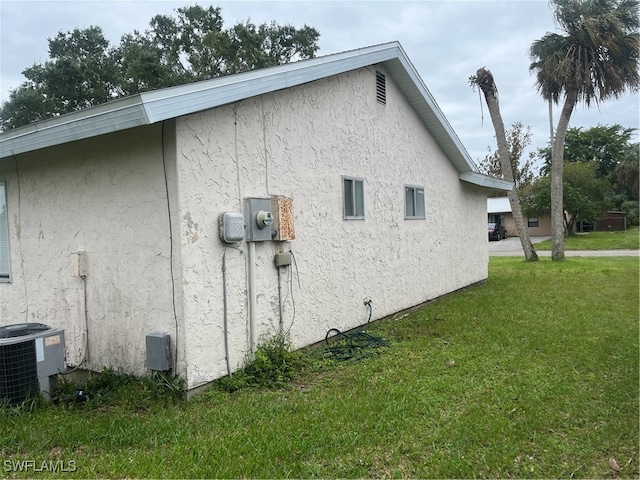 view of property exterior featuring central air condition unit and a lawn