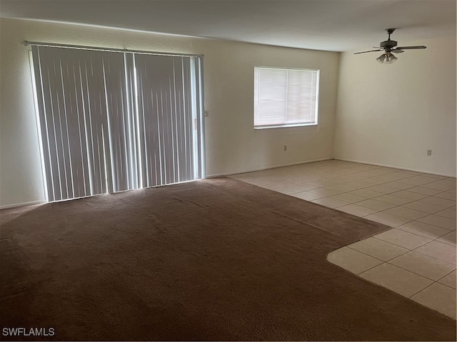 tiled spare room with ceiling fan