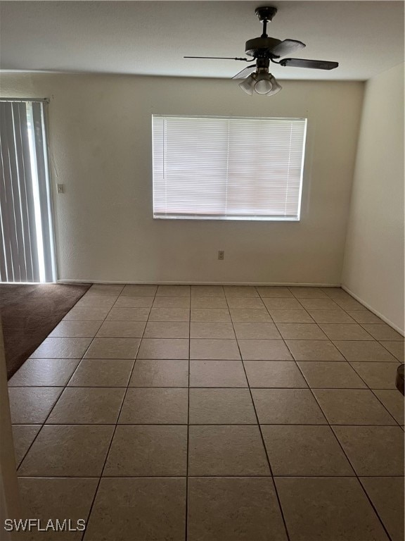 tiled empty room with plenty of natural light and ceiling fan