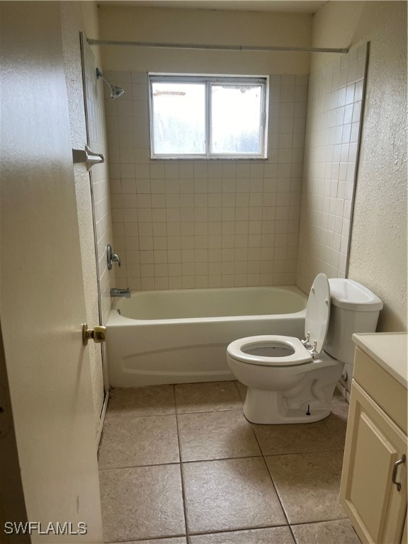 full bathroom featuring tiled shower / bath, vanity, toilet, and tile patterned flooring