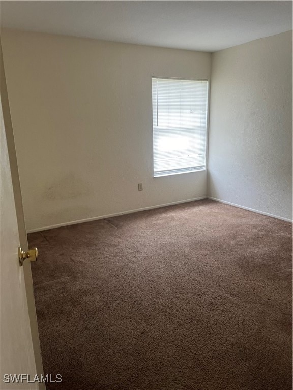 unfurnished room with dark colored carpet