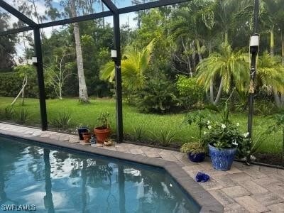 view of pool with a yard and a lanai