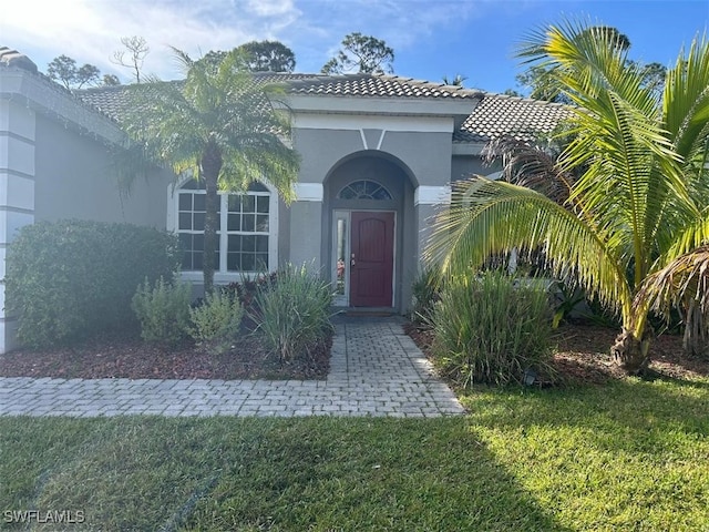 property entrance with a lawn