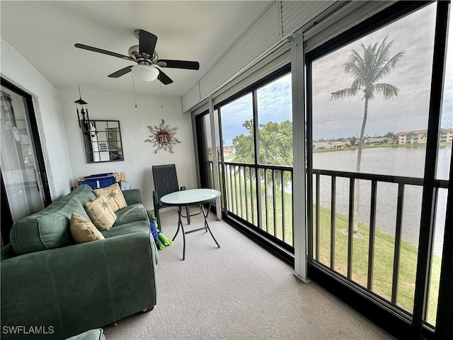 sunroom / solarium with a water view and ceiling fan