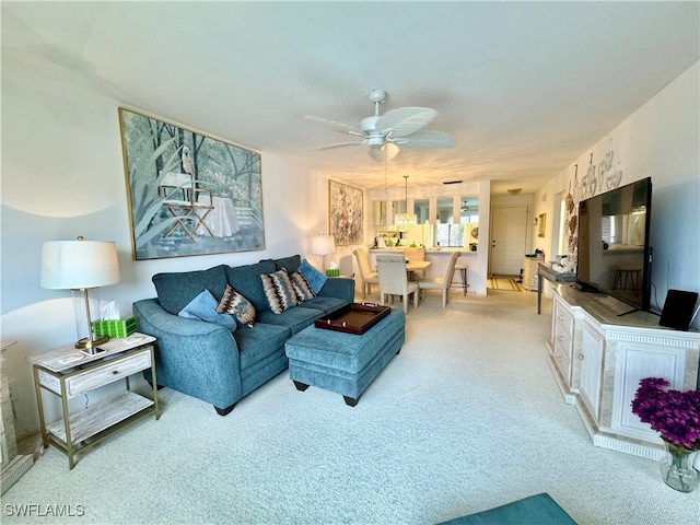 carpeted living room with ceiling fan