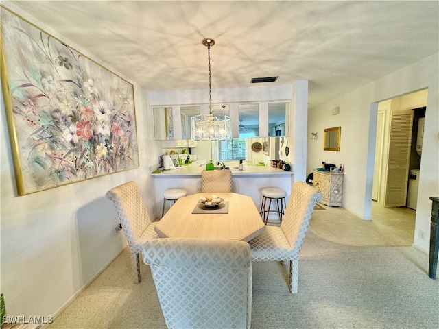 dining room featuring light carpet and a notable chandelier