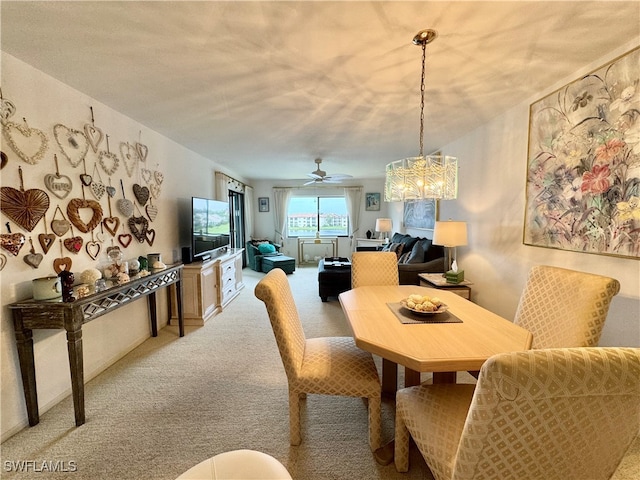 carpeted dining room featuring ceiling fan with notable chandelier