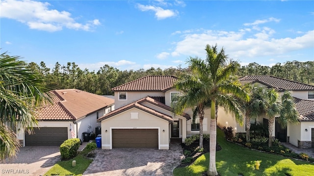 mediterranean / spanish home featuring a garage and a front lawn