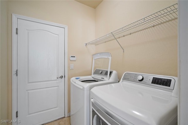 washroom with separate washer and dryer and light tile patterned floors