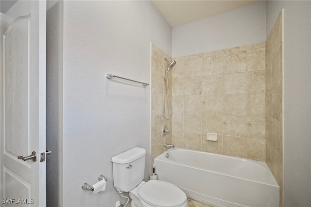 bathroom featuring tiled shower / bath and toilet