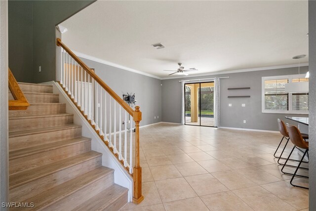 tiled foyer with ornamental molding and ceiling fan