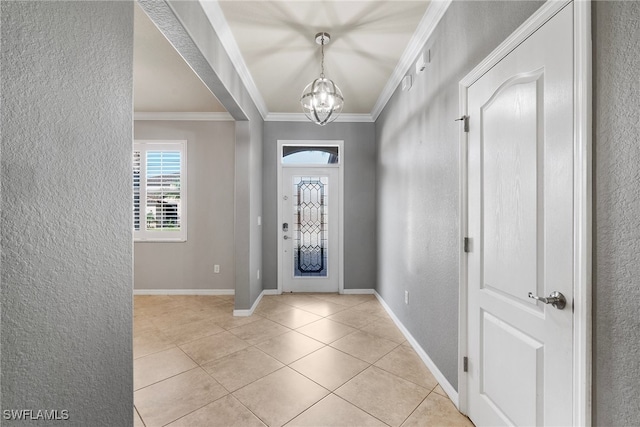 tiled entrance foyer featuring a notable chandelier and ornamental molding