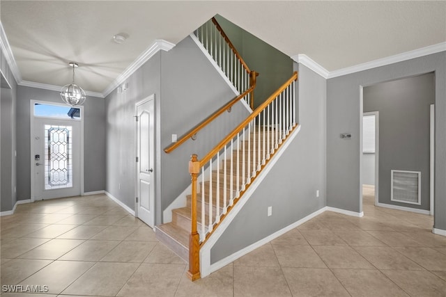 tiled entrance foyer featuring an inviting chandelier and ornamental molding