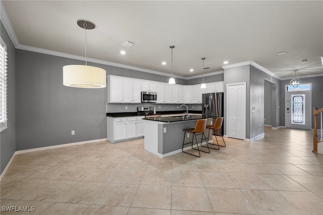 kitchen featuring a kitchen island with sink, crown molding, sink, white cabinetry, and appliances with stainless steel finishes