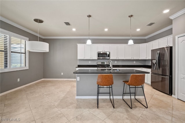 kitchen featuring decorative backsplash, appliances with stainless steel finishes, crown molding, and white cabinetry