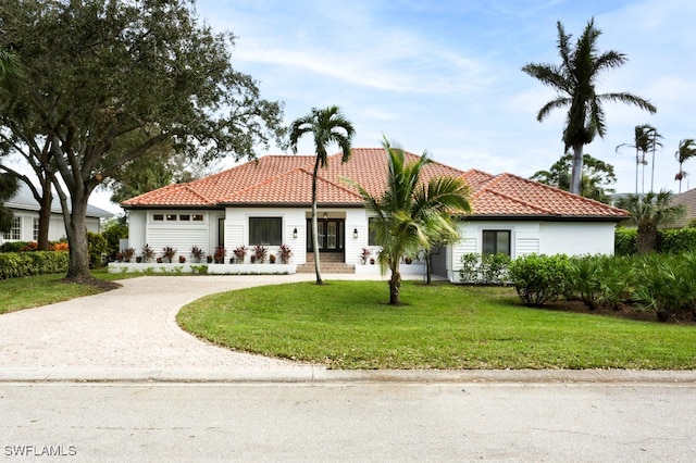 mediterranean / spanish house with a front lawn